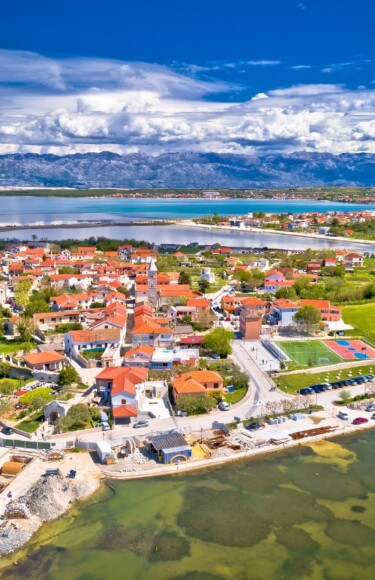 Panoramski pogled na povijesni grad Nin u Hrvatskoj s morem, planinama i solanama u pozadini