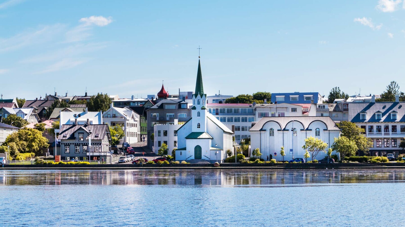 reykjavik-glavni-grad-islanda Pogled na centar Reykjavíka s jezerom Tjörnin u prvom planu i prepoznatljivom crkvom Fríkirkjan