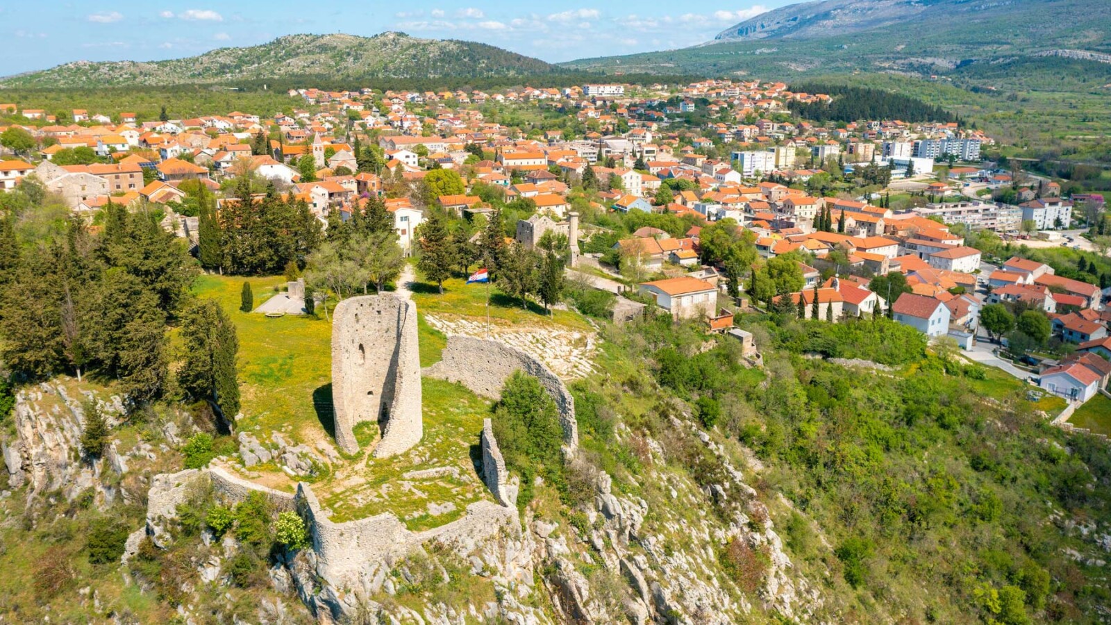 grad-drnis-panorama Pogled na Drniš i stari grad s utvrdom na stijeni – povijesna i kulturna znamenitost Dalmacije, idealna destinacija za istraživanje.