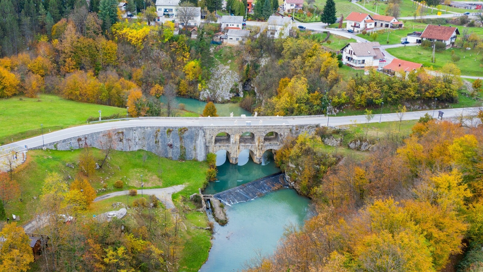 Tounjski most iz zraka u jesenskom okruženju, povijesna dvokatna kamena građevina iznad rijeke Tounjčice u Karlovačkoj županiji