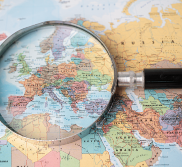 Detaljan prikaz europskih država kroz povećalo postavljeno na karti svijeta.