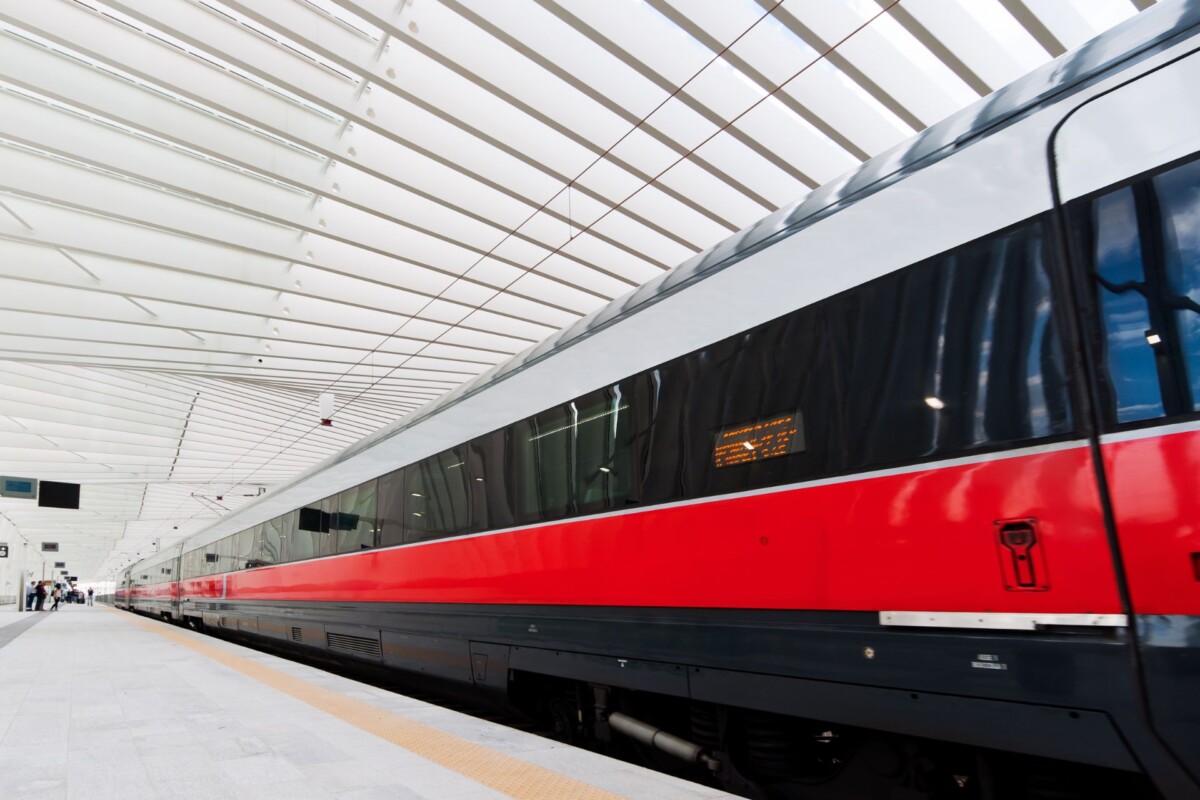 Najbrži vlak u Europi, poznat kao Crvena strijela (Frecciarossa), stoji na modernoj željezničkoj stanici u Italiji. Njegov elegantni crveno-crni dizajn i futuristička infrastruktura odražavaju visoku brzinu i tehnološku naprednost talijanskih brzih željeznica.