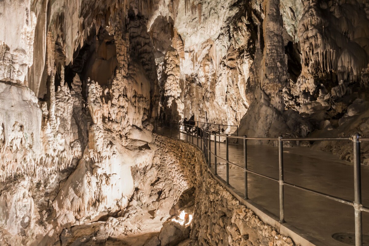 Unutrašnjost Postojnske jame u Sloveniji, s uređenom stazom za posjetitelje među impresivnim sigama i podzemnim dvoranama