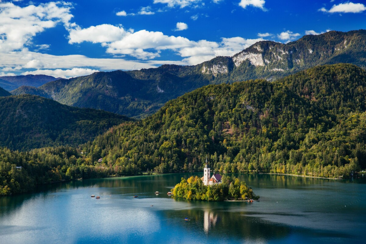 slovenija-jezero-bled-alpe Bledsko jezero u Sloveniji s crkvom na otočiću, okruženo planinama i šumom – popularna turistička atrakcija i simbol slovenske prirodne ljepote.
