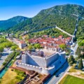 ston-stonske-zidine Pogled iz zraka na Ston s impozantnim zidinama, tvrđavom i zelenim brdima u pozadini.