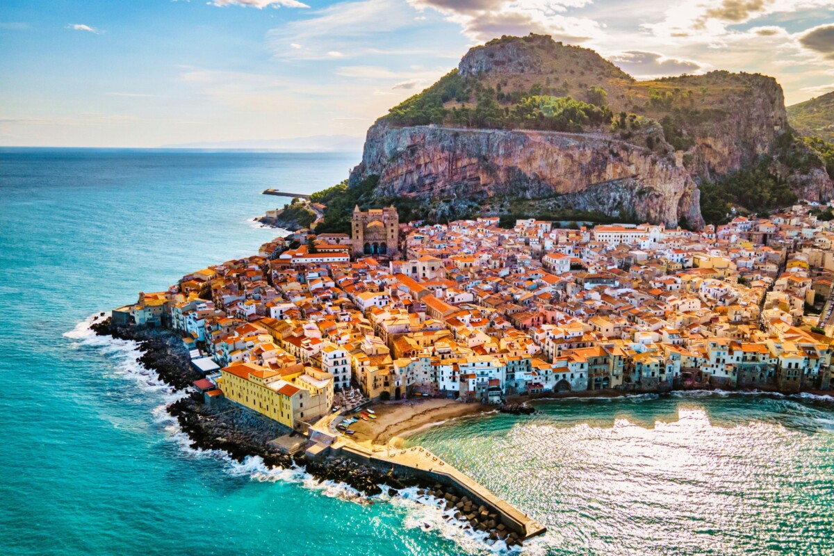 cefalu-sicilija-italija Pogled na obalni grad Cefalù na Siciliji s karakterističnom stijenom u pozadini i plavetnilom Tirenskog mora