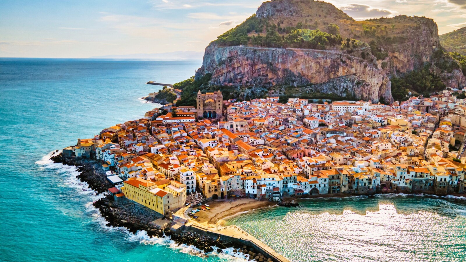 cefalu-sicilija-italija Pogled na obalni grad Cefalù na Siciliji s karakterističnom stijenom u pozadini i plavetnilom Tirenskog mora