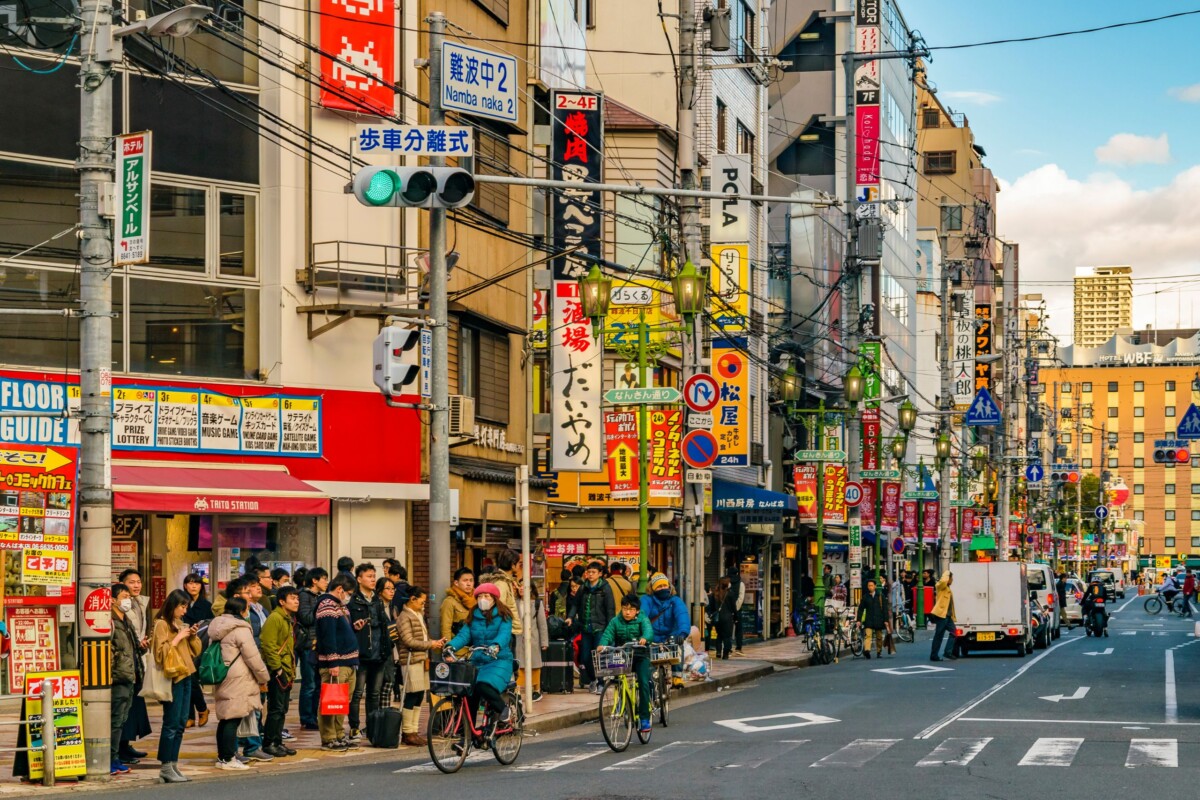 Ulica u Osaki prepuna ljudi, trgovina i šarenih neonskih natpisa u japanskom stilu