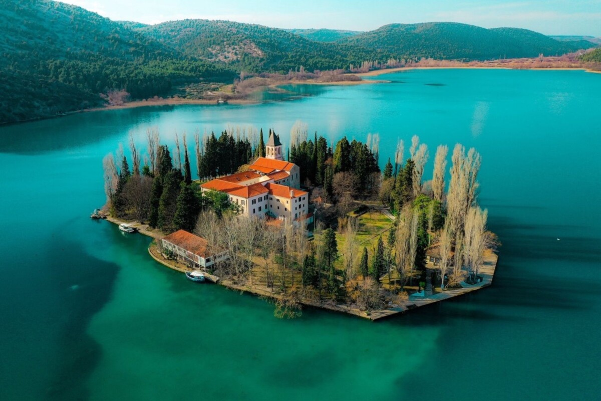 nacionalni-park-krka-visovac Otočić Visovac s franjevačkim samostanom na rijeci Krki, okružen smaragdno zelenom vodom i netaknutom prirodom Nacionalnog parka Krka