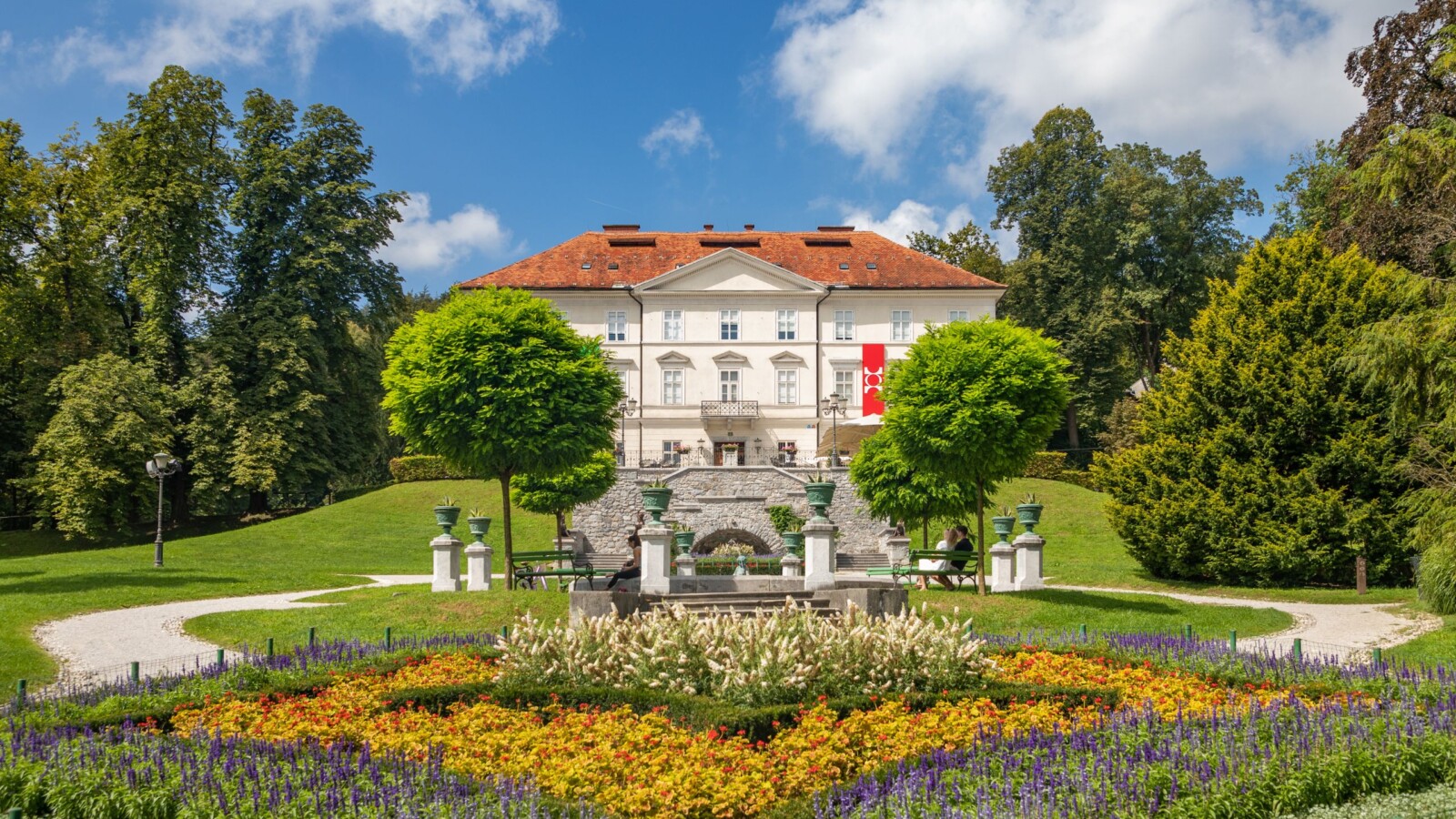 park-tivoli-ljubljana-dvorac Park Tivoli u Ljubljani s raskošnim cvjetnjakom, uređenim stazama i povijesnom vilom u pozadini, popularna atrakcija i najveći park u glavnom gradu Slovenije.