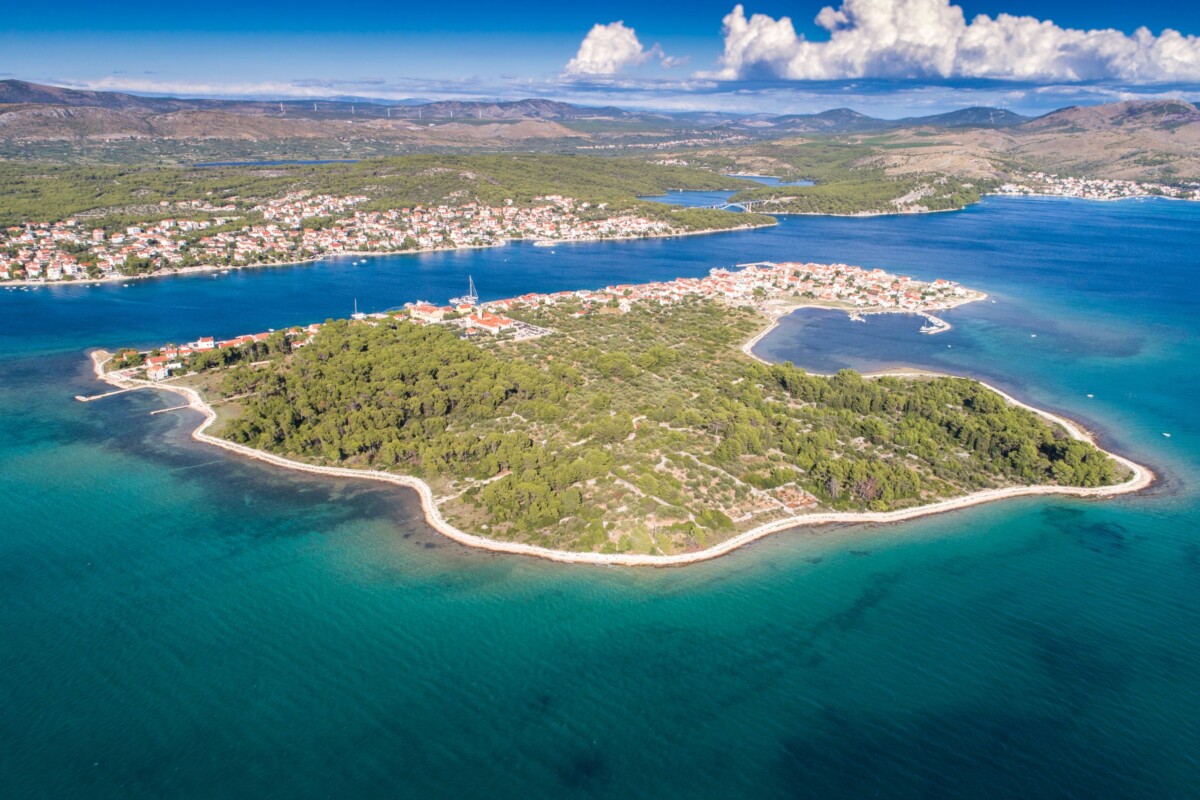 otok-krapanj-iz-zraka Otok Krapanj, najniži hrvatski otok, snimljen iz zraka, okružen tirkiznim morem. U daljini se vidi Brodarica