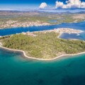 otok-krapanj-iz-zraka Otok Krapanj, najniži hrvatski otok, snimljen iz zraka, okružen tirkiznim morem. U daljini se vidi Brodarica