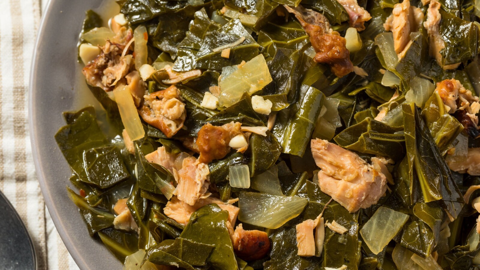 Tradicionalno jelo od kuhane raštike s komadićima suhog mesa i povrća, posluženo na tanjuru – omiljeni zimski obrok u Dalmaciji.