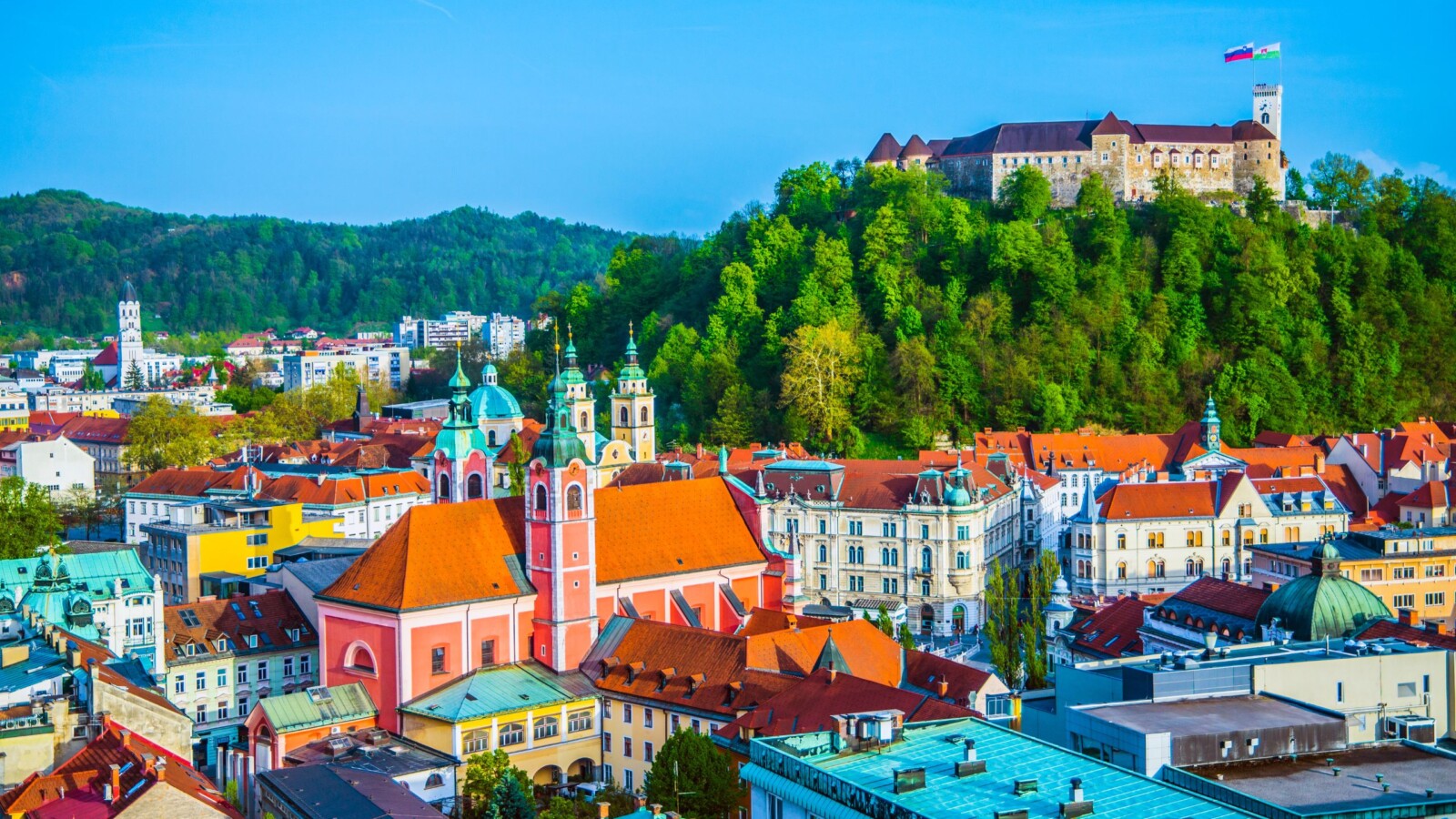 slovenija-ljubljana Pogled na centar Ljubljane s baroknom crkvom i Ljubljanskim gradom na brežuljku – glavni grad Slovenije poznat po zelenim površinama i održivom turizmu.