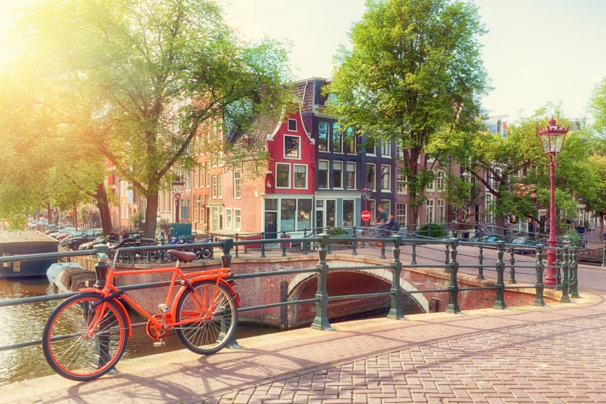 Šarmantni kanal u Amsterdamu s biciklom i tradicionalnim kućama u pozadini.