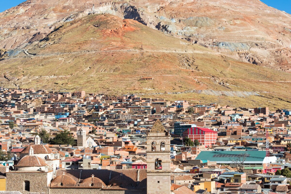 Pogled na grad Potosí u Boliviji s poznatom planinom Cerro Rico u pozadini. Ova planina, nekad izvor ogromnog bogatstva zbog rudnika srebra, dominira krajolikom s vidljivim tragovima rudarskih aktivnosti.