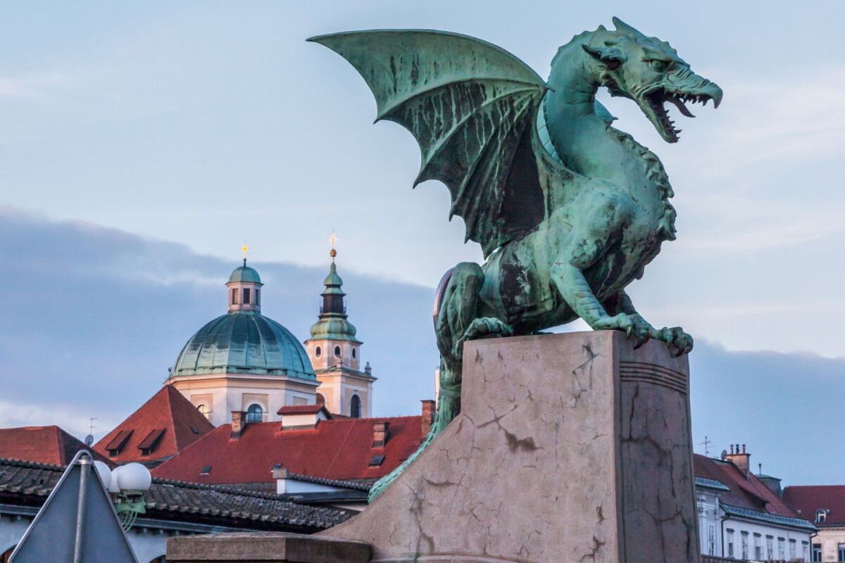 kip-zmaja-ljubljana Zmaj na Zmajskom mostu u Ljubljani, ikonski simbol grada s pogledom na staru jezgru i crkvene tornjeve, jedna od najpoznatijih atrakcija glavnog grada Slovenije.