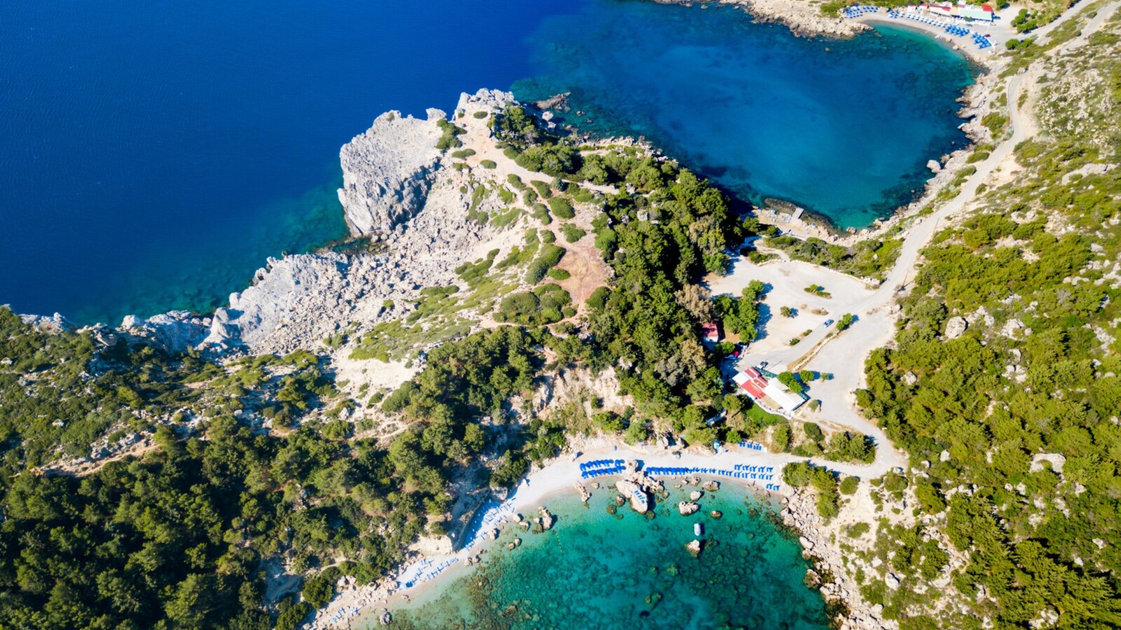 rodos-najljepsa-plaza-uvala Zračna fotografija prekrasne uvale Anthony Quinn Bay na grčkom otoku Rodos, s kristalno čistim morem, stjenovitom obalom i plažom okruženom zelenilom.
