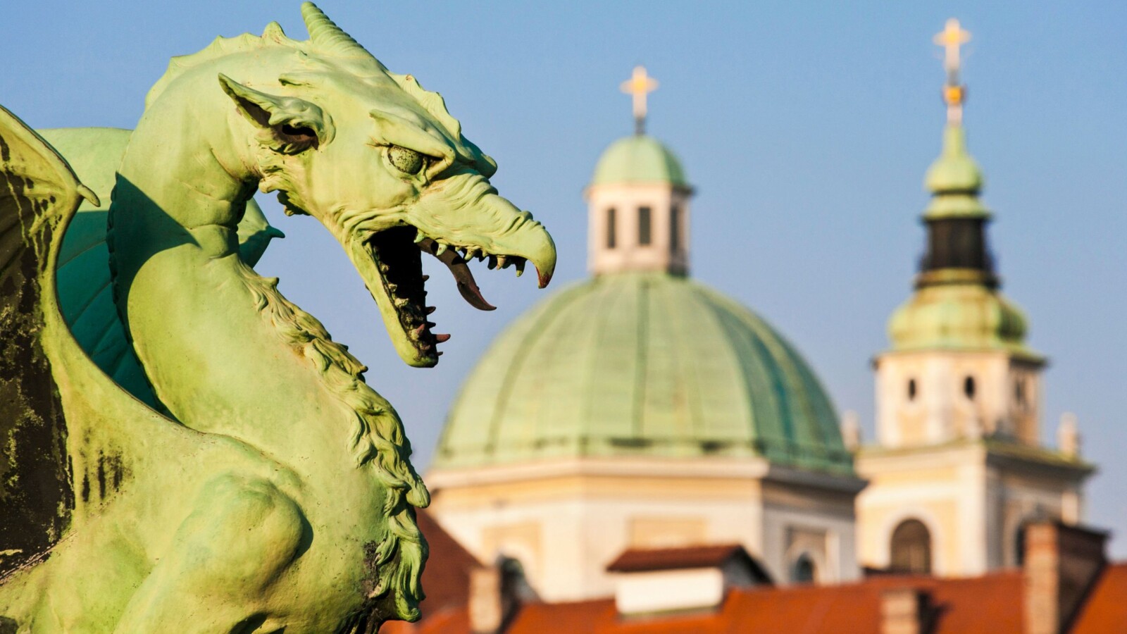 Zmaj s poznatog Zmajskog mosta u Ljubljani s pogledom na katedralu sv. Nikole, jedan od najslavnijih simbola glavnog grada Slovenije.