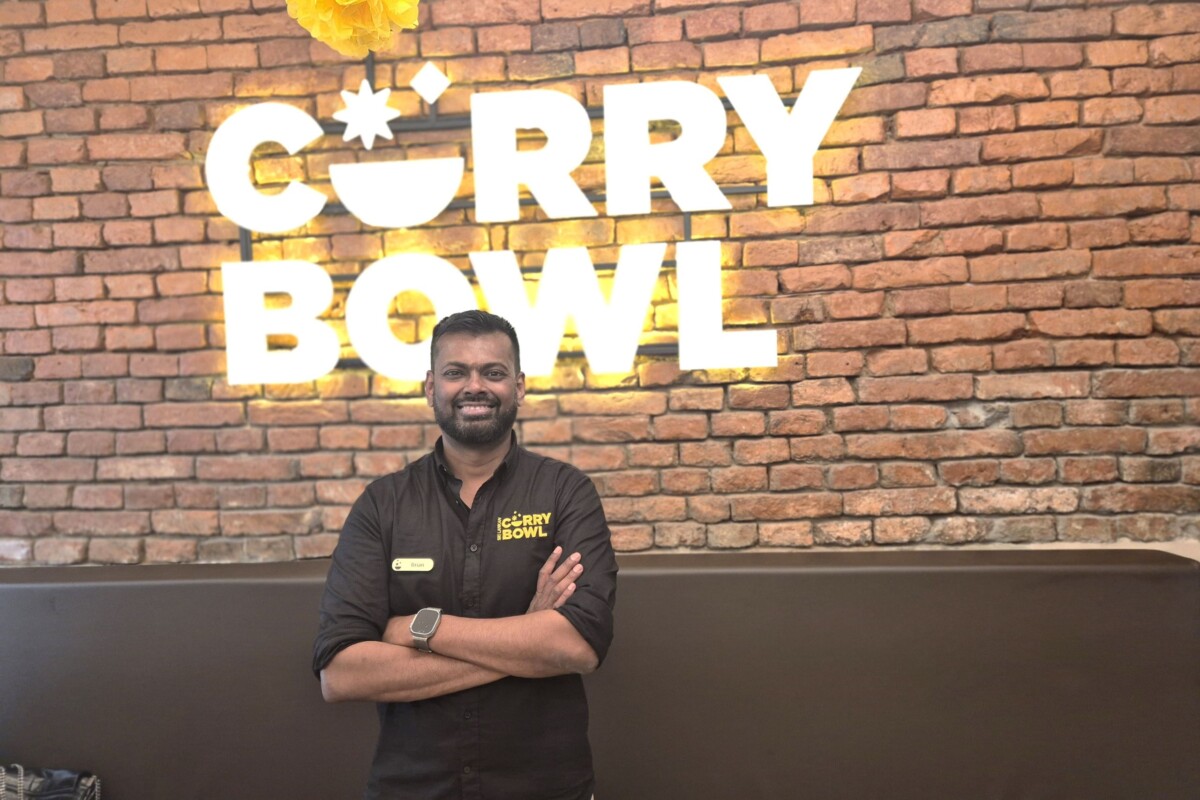 Brian Senaratne, vlasnik restorana Curry Bowl ispod znaka s imenom