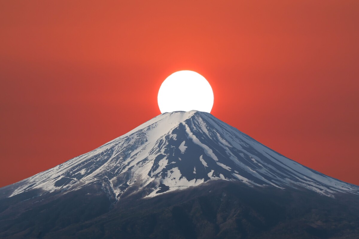 Vrh planine Fuji obasjan zalaskom sunca na crvenom nebu
