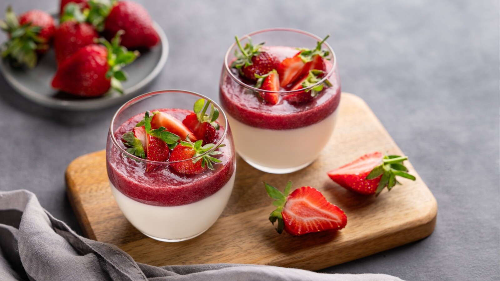 Jednostavan panna cotta s jagodama recept prikazan u dvije čaše s dekoracijom