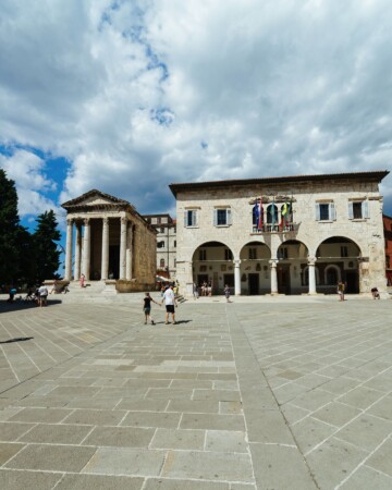 Pogled na Augustov hram na pulskom Forumu, okružen turistima i povijesnim zgradama