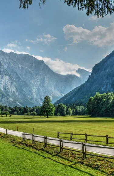 logarska-dolina Pogled na idiličnu Logarsku dolinu u Sloveniji s planinskim vrhovima u pozadini, zelenom livadom i šetnicom uz drvenu ogradu