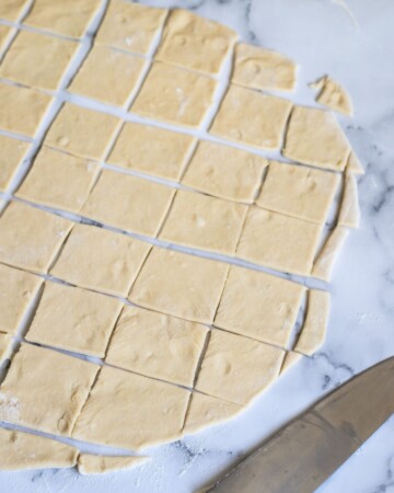 Razvaljano tijesto izrezano na kvadrate – početak oblikovanja klepa, ili bosanski ravioli