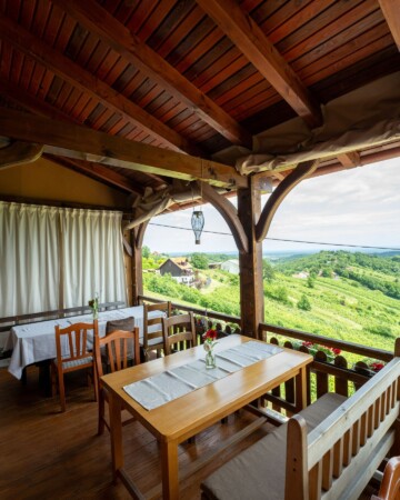 Terasa restorana Karlo s drvenim stolovima i pogledom na zelene vinograde Plešivice.