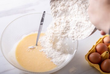 Dodavanje brašna u smjesu s jajima, početak miješanja tijesta za kroštule.