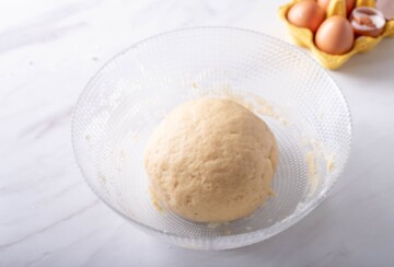 Glatko tijesto nakon miješenja, ostavljeno u zdjeli na odmor. Recept za kroštule.