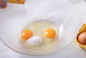 Razbijena jaja sa šećerom u prozirnoj zdjeli, početak pripreme smjese za kroštule.