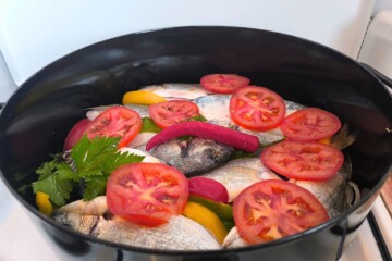 Svježa riba složena u loncu s paprikom, rajčicama i listovima celera, pripremljena za kuhanje tradicionalnog dalmatinskog brudeta. Najbolji recept za brudet s bijelom ribom.