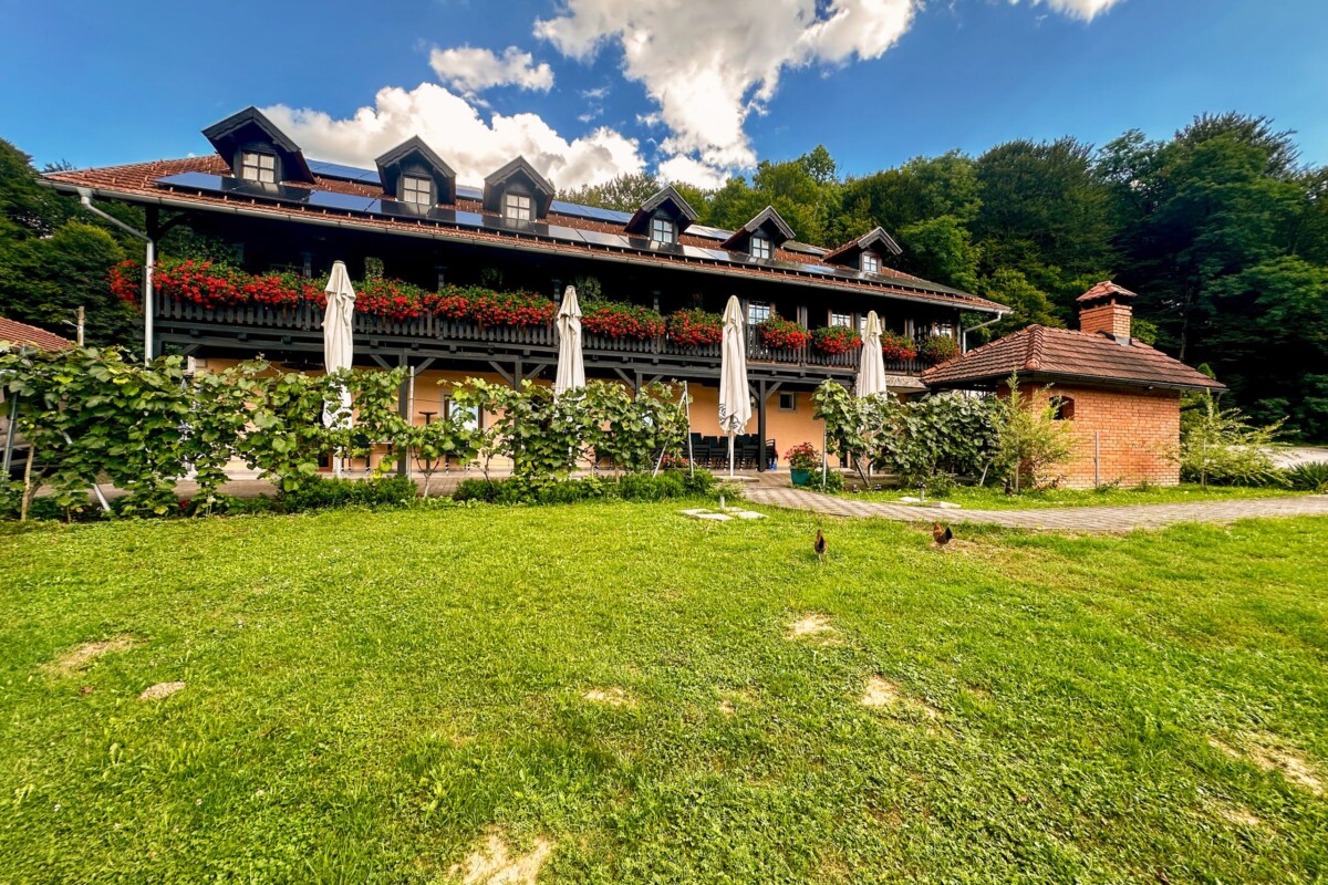 Restoran Lojzekova hiža u Zagorju, tradicionalna kuća s cvijećem na balkonu, terasom i zelenim dvorištem