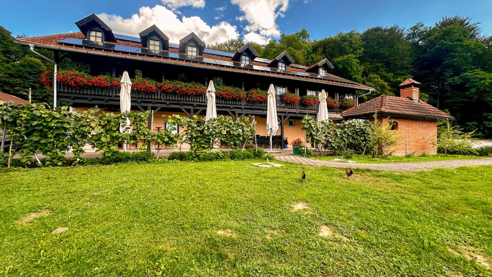 lojzekova-hiza Restoran Lojzekova hiža u Zagorju, tradicionalna kuća s cvijećem na balkonu, terasom i zelenim dvorištem