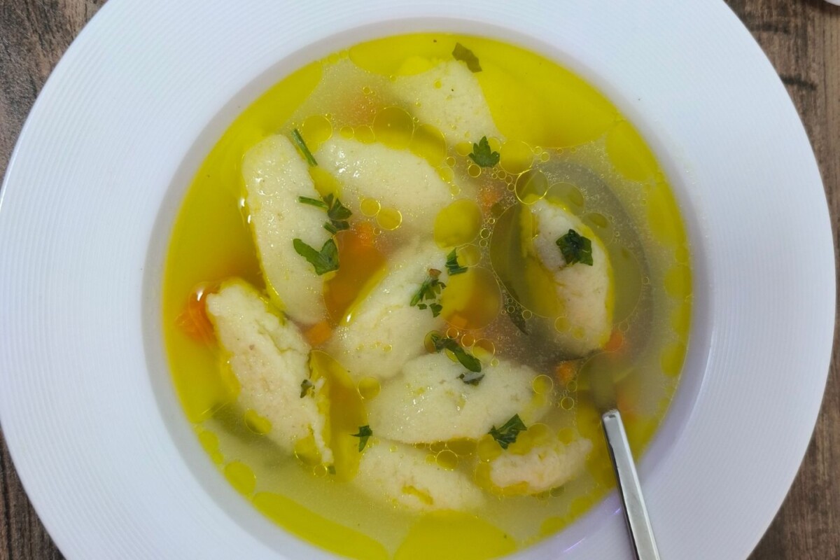 Bijeli tanjur pun pileće juhe s noklicama, mrkvom i svježim peršinom. Domaća pileća juha s noklicama – recept koji spaja jednostavne sastojke u savršenu juhu za svaku priliku, od ručka do svečane večere.