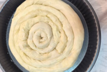 Sirova pita od krumpira složena u obliku spirale prije pečenja