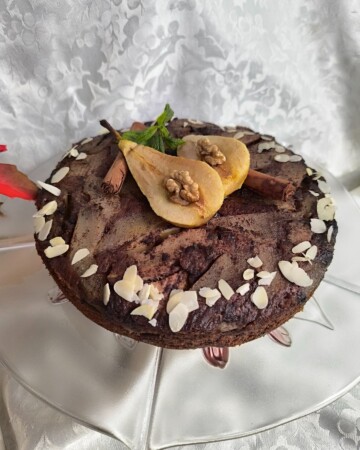 torta-s-kruskama-1 Gotova torta s karameliziranim kruškama poslužena na stalku, s bademima na vrhu