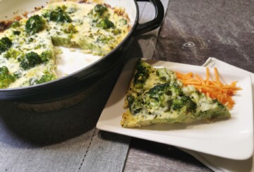 Pečena fritaja od brokule u tavi, poslužena s kriškom na tanjuru.