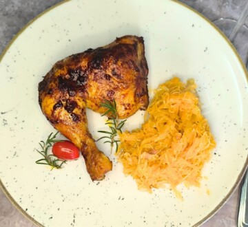 Pileći batak pečen do tamne karamelizacije, poslužen uz kiseli kupus na tanjuru