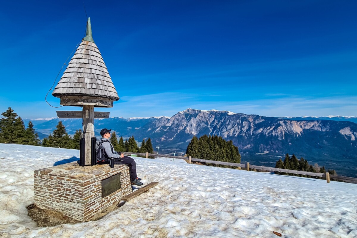 Vrh Peč u Sloveniji, odnosno tromeja, kip, planinar i snježni okoliš