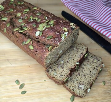 najbolji-proteinski-kruh-recept Narezani domaći proteinski kruh s bučinim sjemenkama na dasci za rezanje