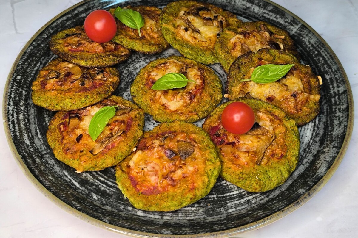 Pizza od brokule pečena u pećnici, poslužena na tanjuru s cherry rajčicama i svježim bosiljkom