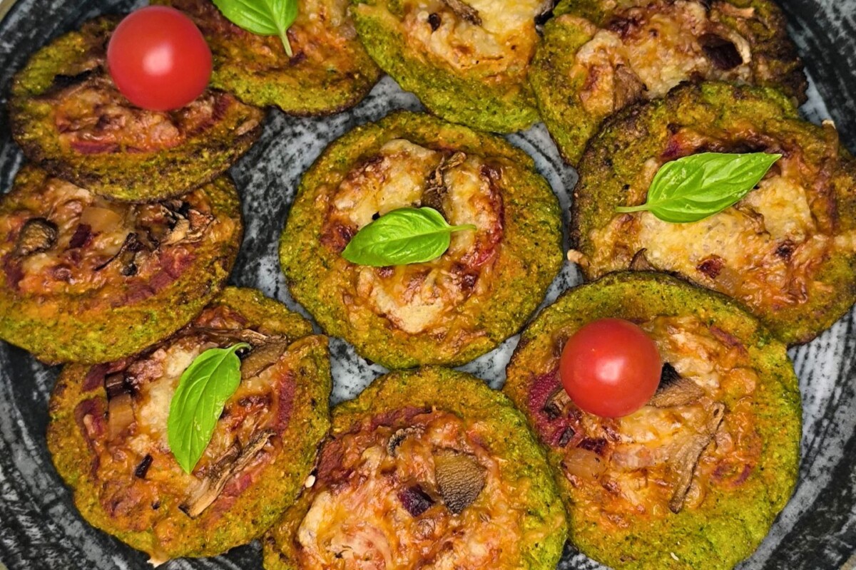 Hrskave pizzete od brokule s rastopljenim sirom, servirane na tamnom pladnju.