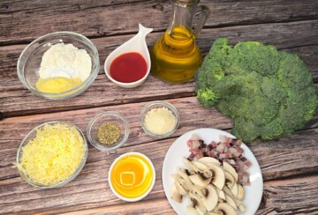 Sastojci za pizzu od brokule – brokula, sir, jaje, gljive i začini na drvenoj podlozi.