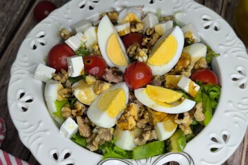 Detaljan prikaz salate s narezanima jajima, komadićima tune, avokadom i cherry rajčicama.