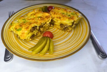Porcija sočne musake na tanjuru uz kiseli prilog