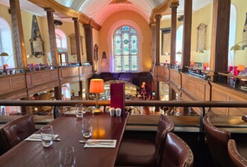 Stol u restoranu The Church u Dublinu s pogledom na bar i unutrašnjost crkve. Crkva Svete Marije u Dublinu.