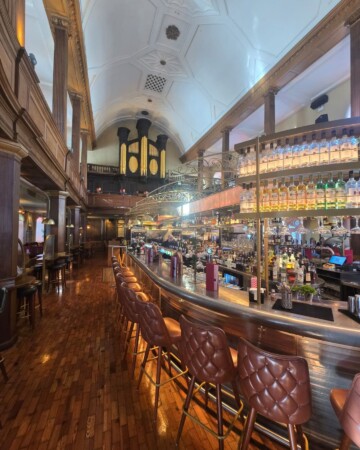 Interijer The Church bara u Dublinu s dugim šankom i visokim crkvenim svodovima